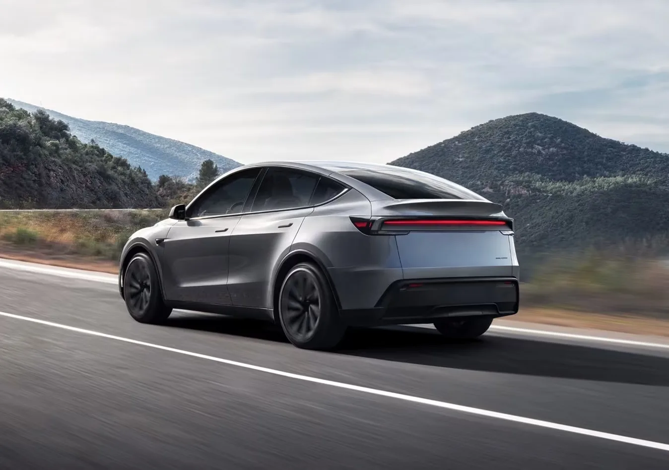 Silver Model Y driving away on a highway